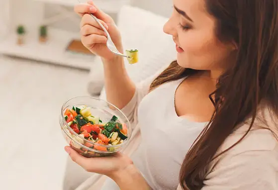 Dieta saludable en la preconcepción reduce riesgos Embarazada comiendo una dieta saludable durante la preconcepción