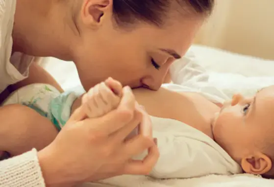 Mama dando besos a panza de bebe