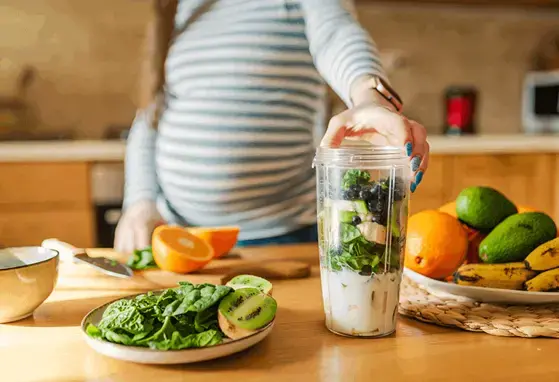 Buena alimentación embarazo evita DEC Embarazada preparando una dieta sana y nutritiva