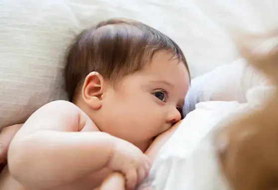 Una madre amamanta a su pequeña bebé.