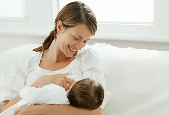 La leche materna puede llegar a tener efectos en la vida adulta. Una madre se alista para empezar a amamantar a su bebé.