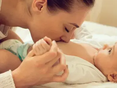 Mama dando besos a panza de bebe