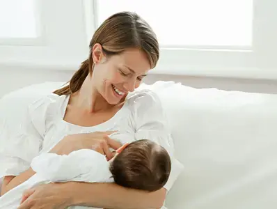 Una madre se alista para empezar a amamantar a su bebé. 
