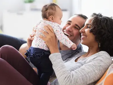 Los probioticos pueden mejorar la infertilidad Padres felices cargando a su bebé