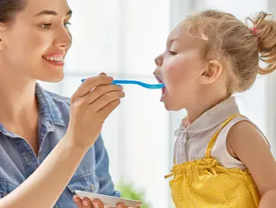 Mamá dando de comer a su hija Mamá dando de comer a su hija