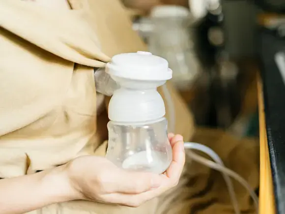 Una madre un extractor de leche materna para alimentar a su bebé.